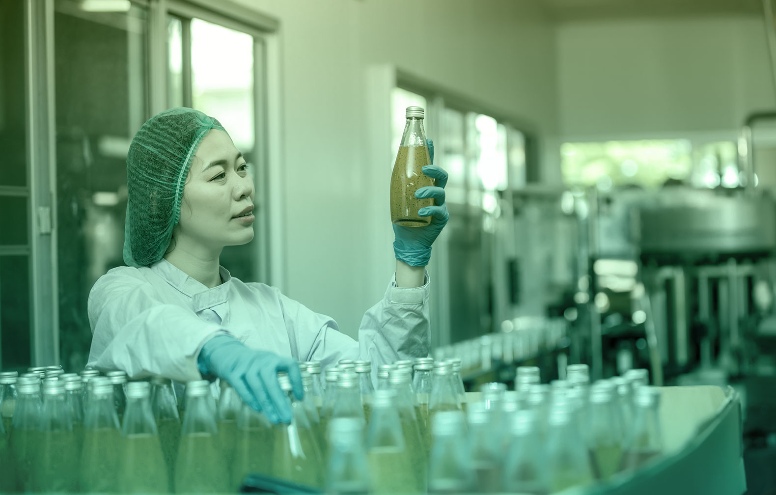 Factory Food technician observing bottled chia seed beverage