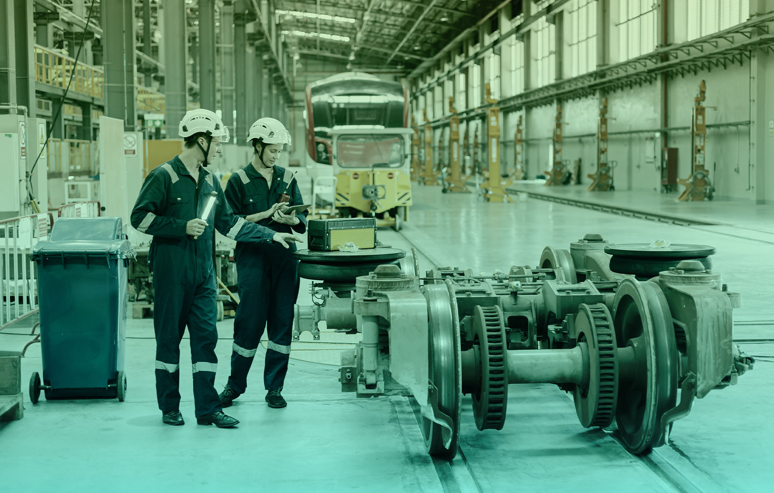 maintenance technicians for rail transport performing maintenance on a train and rails and loggin information in a tablet