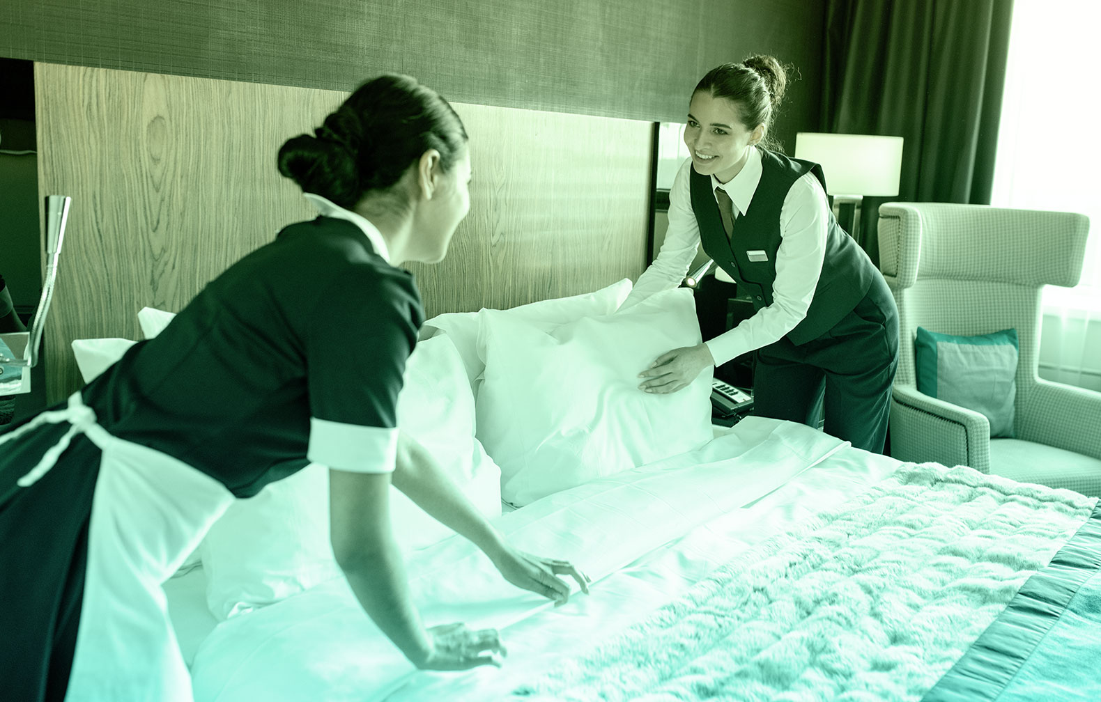 housekeeping team maintaining a bed which is the most important asset for a hotel