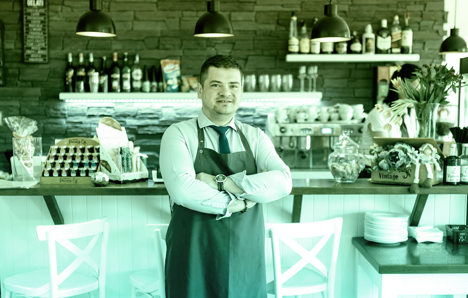 waiter looking at the camera with a bar in the background