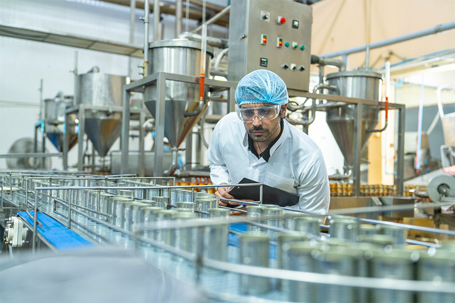 Food technician making observations on the effects of machinery on products and annotating on the CMMS app